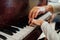 Hand of an experienced pianist helping young students