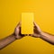 Hand extends box towards phone, against lively yellow backdrop intriguing convergence