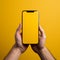 Hand extends box towards phone, against lively yellow backdrop intriguing convergence