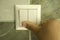 Hand extinguishes the light in the bathroom using a wall switch