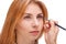 Hand with eyelash tweezers at the face of a girl close-up on a white isolated background