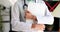 Hand of female doctor with clipboard in clinic