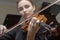 Hand of a female violinist on the fingerboard of a violin takes a chord during music performance