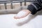 Hand of female worker of polymer processing factory with pile of plastic pellets