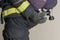 Hand of a firefighter opens a cylinder with compressed air for breathing in a smoky room, close-up, side view