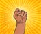 Hand in fist as pop art style. I can do it. Be strong. Hand of African American woman on yellow sun background. Vector