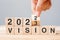 Hand flipping block 2022 to 2023 VISION text on table. Resolution, strategy, goal, motivation, reboot, business and New Year