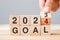 hand flipping block 2023 to 2024 GOAL text on table. Resolution, strategy, plan, motivation, reboot, business and New Year holiday
