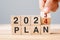 hand flipping block 2023 to 2024 PLAN text on table. Resolution, strategy, goal, motivation, reboot, business and New Year holiday
