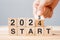 hand flipping block 2023 to 2024 START text on table. Resolution, strategy, goal, motivation, reboot, business and New Year