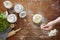 Hand and flour dough on wooden table