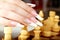 Hand with french manicure playing chess