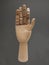 Hand: front wooden palm with an intense dark gray background. close-up of a wooden object