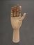 Hand: front wooden palm with an intense dark gray background. close-up of a wooden object
