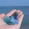 Hand full of seaglass. Woman picking sea finds on sea shore. Beach walk