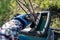 hand of the gardener puts branches in garden shredder close-up. Shredding tree branches during spring harvesting.