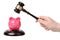 Hand with gavel beats on a piggy bank