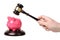 Hand with gavel beats on a piggy bank