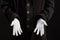 Hand gestures. Showman or magician illusionist in white gloves on a black background.