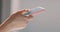 Hand of girl using smartphone at bedroom at home, typing message. Close-up of young women hand. Side view.