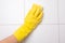 Hand in glove cleaning tile wall