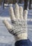 Hand in glove covered with snow in winter day