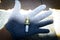 Hand with glove holding spark plug