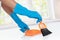 Hand with glove using cleaning broom to clean up