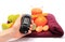 Hand with glucometer, fruits, tape measure, juice and dumbbells