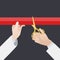 Hand with golden scissors cut the red ribbon