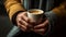 Hand grasping warm coffee cup