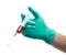 Hand with green glove holding syringe for Injecting