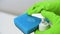 Hand in green glove push dispenser and liquid detergent squeezed to blue sponge