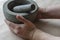 Hand grinds the dried roots of medicinal herbs in stone mortar