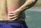 The hand grips the waist that inflammation from a sports injury