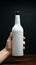 Hand grips a white labeled bottle, a minimalist design in the person\\\'s grasp