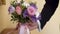 Hand of the groom takes a wedding bridal bouquet from a vase in slow motion