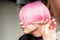 Hand of a hairdresser cutting short pink with scissor hair in a hairdressing salon, close up, side view.