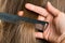 Hand of hairdresser with strand of hair and comb