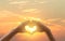 Hand on heart sunset background. The light filtering through the heart Shows love