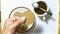 Hand hold brown biscuits in dish pairing with black coffee with