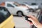 Hand hold car key remote on blur car parking