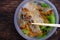 Hand hold chopsticks pick up fried spring rolls on vegan rice noodles