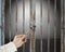 Hand hold key opening locked door with empty space in gray concrete wall background