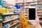 Hand hold mobile smart phone in Pharmacy blurred background