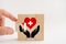 Hand hold piece of cube to complete helping hand with red heart above for life health insurance services, insurance business and