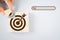 hand hold piece of wooden cube to complete dartboard icon shape with search bar beside, brainstorming for target or goal