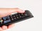 A hand hold and press at power button on television remote control