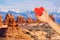 Hand hold red heart over Mt Waas and Arches park