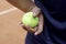 Hand hold Tennis ball on clay court. Red clay tennis court. Sand on a tennis court. The tennis court on clay. Tennis Clay Court